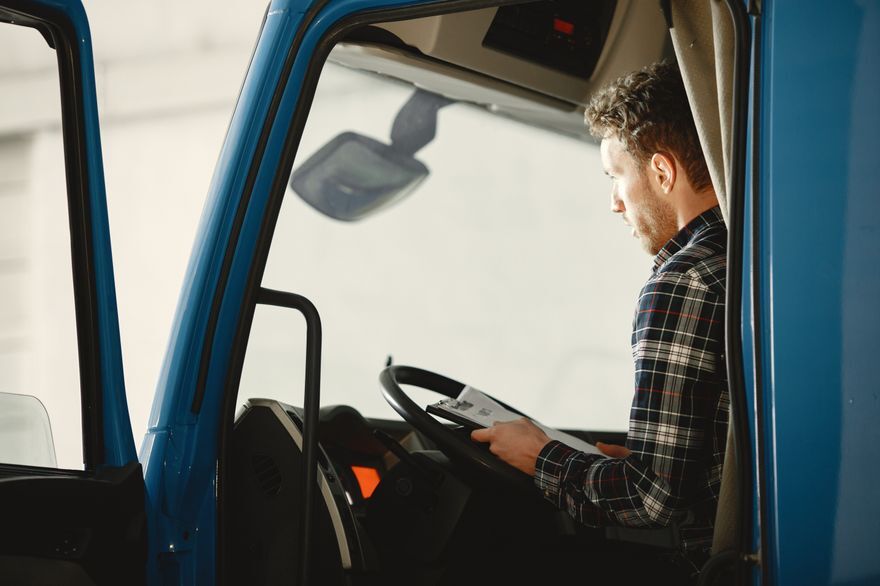 Delivery driver checking paperwork in the cab of a truck